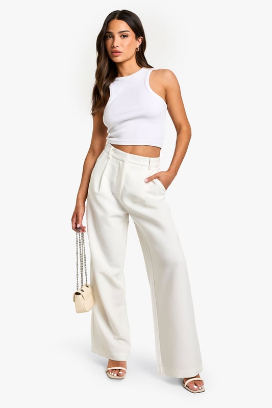 Wide-leg design for a relaxed and comfortable fit
        High-waisted silhouette to elongate the legs
        Side pockets for practicality and style
        Versatile woven fabric suitable for various occasions
        Petite sizing for a perfect fit on smaller frames
    
    These essential wide-leg trousers are a must-have addition to your wardrobe, offering both style and comfort for the fashion-forward woman. The high-waisted design creates a flattering silhouette, while the relaxed wide-leg cut allows for easy movement and a trendy look. Perfect for casual outings or dressed up for more formal events, these trousers can be styled in numerous ways. Pair them with a fitted crop top and strappy sandals for a chic summer ensemble, or dress them up with a tucked-in blouse and heels for a sophisticated office look. The side pockets add a practical touch, making these trousers ideal for everyday wear. Whether you're heading to a family gathering or a casual lunch with friends, these versatile trousers will keep you looking effortlessly stylish and feeling confident throughout the day.