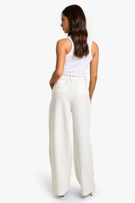 Wide-leg design for a relaxed and comfortable fit
        High-waisted silhouette to elongate the legs
        Side pockets for practicality and style
        Versatile woven fabric suitable for various occasions
        Petite sizing for a perfect fit on smaller frames
    
    These essential wide-leg trousers are a must-have addition to your wardrobe, offering both style and comfort for the fashion-forward woman. The high-waisted design creates a flattering silhouette, while the relaxed wide-leg cut allows for easy movement and a trendy look. Perfect for casual outings or dressed up for more formal events, these trousers can be styled in numerous ways. Pair them with a fitted crop top and strappy sandals for a chic summer ensemble, or dress them up with a tucked-in blouse and heels for a sophisticated office look. The side pockets add a practical touch, making these trousers ideal for everyday wear. Whether you're heading to a family gathering or a casual lunch with friends, these versatile trousers will keep you looking effortlessly stylish and feeling confident throughout the day.