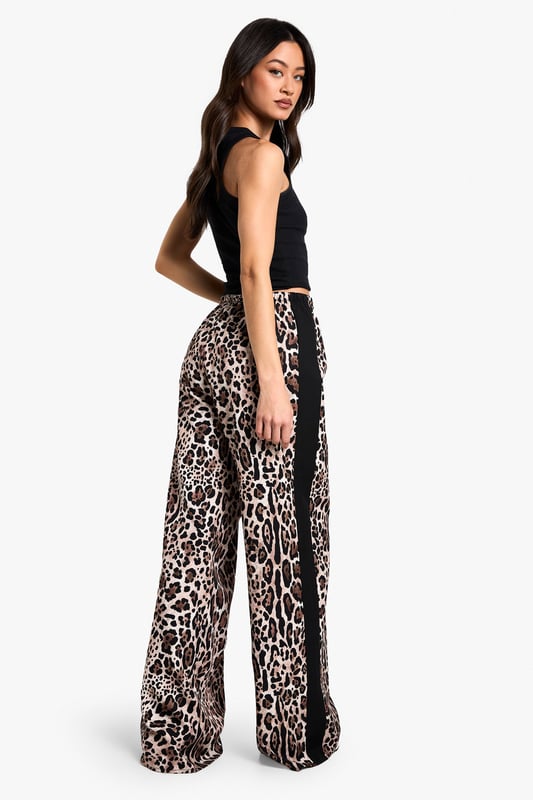 Eye-catching leopard print pattern
        Flattering wide-leg silhouette
        Contrasting side stripes for added flair
        High-waisted design for a lengthening effect
        Lightweight woven fabric for all-day comfort
    
    Make a bold statement with these striking leopard print trousers, perfect for the fashion-forward Boohoo girl. The wide-leg cut offers a relaxed fit that's both on-trend and comfortable, while the high waist creates a flattering silhouette. The contrasting side stripes add a sporty edge, making these trousers versatile enough for various casual occasions. Style them with a cropped black top and trainers for a laid-back daytime look, or dress them up with a sleek bodysuit and heels for a night out with friends. These trousers are ideal for family gatherings, brunch dates, or casual shopping trips. The lightweight fabric ensures you'll stay cool and comfortable, no matter where your day takes you. Embrace your wild side and stand out from the crowd in these eye-catching trousers that perfectly blend comfort with cutting-edge style.
