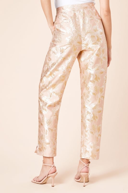 Elegant jacquard fabric with a lustrous finish and textured floral pattern
        Sophisticated tapered fit that narrows towards the ankle for a refined silhouette
        Practical side pockets for essential items
        Flattering high-waist design with a sleek waistband
        Ankle-length cut with subtle side slits for enhanced movement and style
    
    These Dorothy Perkins Tailored Jacquard Tapered Trousers offer the perfect balance of sophistication and contemporary style. The exquisite jacquard weave creates a textured finish that catches the light beautifully, making these trousers ideal for special occasions. Style with a crisp white blouse and strappy heels as shown for elegant wedding guest attire, or pair with a coordinating jacquard blazer for a striking head-to-toe look at formal events. The tapered silhouette creates a flattering shape that works wonderfully for race day ensembles or graduation ceremonies. For evening affairs, match with a simple camisole and statement jewellery to let the trousers take centre stage. These versatile occasion trousers transition seamlessly from day to night, offering endless styling possibilities for the fashion-conscious woman who appreciates refined elegance with a contemporary twist.