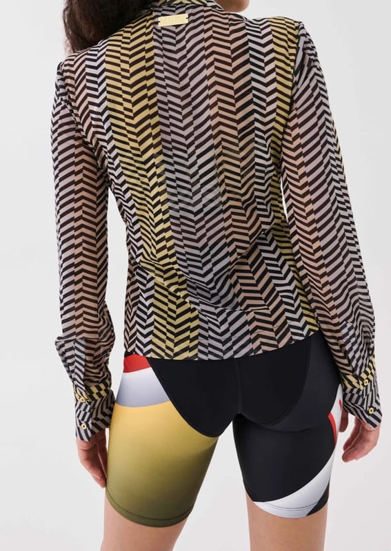 90% Polyester &amp; 10% Elastane. Slightly fitted style shirt with a long pointed collar. Power mesh fabrication ina semi sheer finish. Lined cuffs with buttons to close. P.E Nation gold plated logo badge at the back
