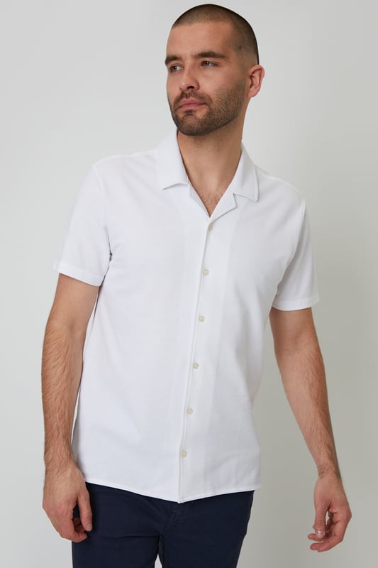This lightweight pique shirt from Threadbare will have you ready for the summer months. Crafted with a from a soft cotton jersey pique, this shirt features a revere collar with single needle stitching and a button-through fastening. The short sleeves and side split vents offer comfort and breathability for warm days. Complete with a back yoke seam for added detail, this shirt is perfect for casual outings or beachside gatherings. Pair it with tailored shorts or lightweight trousers for a relaxed look that's ideal for sunny days and balmy evenings.