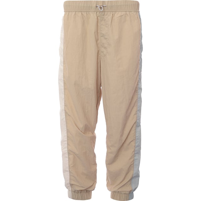 Main: 100% Polyamide. Tommy Jeans nylon blend joggers in beige are the epitome of comfort meets style. With their snug cuffed legs, they offer a modern silhouette that's perfect for a relaxed weekend or a casual outing. The subtle thick stripe down the side adds a touch of sporty elegance, making them a versatile addition to any wardrobe. Whether you're lounging at home or stepping out for a coffee, these joggers blend functionality with a trendy aesthetic.