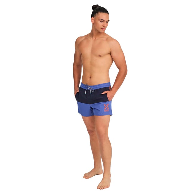 Este bañador hombre corto ofrece un diseño fresco y moderno, ideal para aquellos que buscan comodidad y estilo en sus actividades acuáticas o en días de descanso al sol. Con su tejido ligero y detalles prácticos, es el bañador de hombre perfecto para disfrutar del verano.

Detalles:
- Cintura elástica ajustable con cordón.
- Bolsillos laterales.
- Etiqueta de silicona con relieve en la parte trasera.
- Forro interior de malla.
- Gráficos de la marca.
- Confeccionado en tejido ligero de secado rápido.

Los bañadores de hombre son una prenda indispensable para aquellos que aman disfrutar del agua, ya sea en la playa, en la piscina, o en cualquier otro lugar. Aunque a menudo se consideran como una prenda simple y funcional, el bañador hombre de Munich puede ser una elección de estilo y moda. El bañador largo hombre es una prenda que nos define, por lo que resulta importante dar con un bañador de hombre que nos ayude a proyectar nuestra personalidad.
 Composición: 100% Poliéster
 Cuidados:
Lavar a mano.
No usar lejía ni suavizantes.
Secar al aire libre.