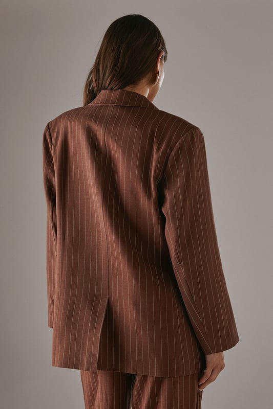 Boxy fit blazer with classic pinstripe pattern for a contemporary twist on tailoring
        Single button fastening creates a clean, streamlined silhouette
        Notched lapel collar adds traditional tailoring detail
        Long sleeves with structured shoulders for a confident, defined shape
        Linen-look fabric offers a textured finish with natural drape
    
    This Warehouse blazer redefines casual sophistication with its relaxed boxy silhouette and distinctive pinstripe pattern. The linen-look fabric creates a textured appearance whilst maintaining a fluid drape that moves beautifully with the body. Style as seen with the matching wide-leg trousers for a coordinated suit that conveys confidence without trying too hard. For daytime engagements, pair with a simple t-shirt and trainers for an effortlessly cool look. When evening calls, swap for a silk camisole and statement jewellery. This versatile piece transitions seamlessly from family gatherings to casual office environments, and even weekend brunches. The relaxed structure makes it ideal for layering over lightweight knits during transitional seasons, whilst the timeless pinstripe pattern ensures this blazer will remain a wardrobe staple for years to come.