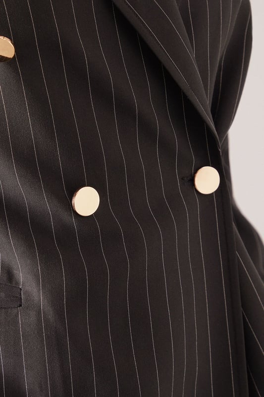 Double-breasted design with striking gold-tone button detailing
        Classic pinstripe pattern for a sophisticated tailored look
        Structured shoulders and notched lapels create a defined silhouette
        Functional front pockets add practicality to this stylish piece
        Comfortable stretch fabric allows for ease of movement throughout the day
    
    This petite double-breasted blazer from Wallis presents the perfect balance of sophistication and contemporary style. The timeless pinstripe pattern creates a refined aesthetic that works beautifully for both office settings and social occasions. Pair with the matching trousers as seen on our model for a coordinated suit look that conveys confidence and poise, or style with dark denim jeans and a simple camisole for a more relaxed approach. The gold-tone buttons add a touch of glamour that's characteristic of the Wallis brand. Perfect for family gatherings when styled with flat shoes and statement jewellery, or dress up with heels and a clutch bag for more formal events. The petite proportions ensure a flattering fit for smaller frames without compromising on style or comfort.