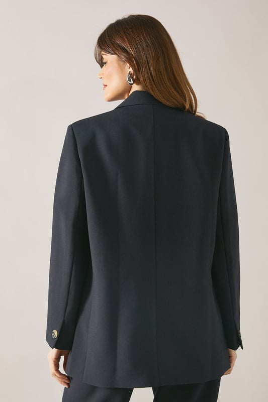 Classic single-breasted design with two-button closure
        Notched lapel for a timeless, sophisticated look
        Long sleeves with button cuffs for a polished finish
        Regular fit offering comfort and ease of movement
        Versatile woven fabric suitable for various occasions
    
    Embrace effortless sophistication with this Wallis single-breasted blazer. Perfect for the woman who appreciates both style and comfort, this versatile piece seamlessly transitions from day to evening wear. The regular fit ensures a flattering silhouette while allowing for easy layering over your favourite tops. Style it with tailored trousers and a crisp white shirt for a smart daytime look, or pair it with a silk camisole and wide-leg trousers for a more relaxed ensemble. For casual outings, throw it over a simple t-shirt and pair with your go-to jeans and trainers. The blazer's adaptability makes it an ideal choice for family gatherings, lunch dates, or casual work environments. Its timeless design ensures it will remain a staple in your wardrobe for seasons to come, offering endless styling possibilities for the modern, sophisticated woman.