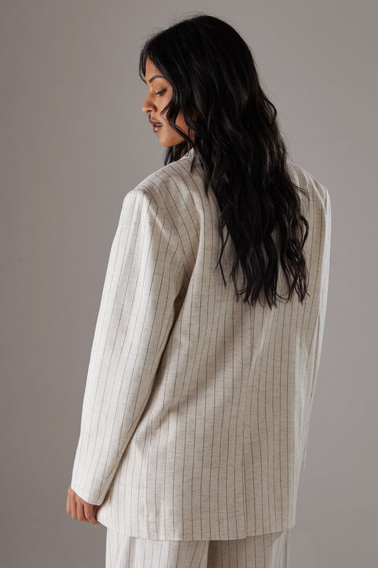 Boxy fit blazer with classic pinstripe pattern for a contemporary twist on tailoring
        Single button fastening creates a clean, streamlined silhouette
        Notched lapel collar adds traditional tailoring detail
        Long sleeves with structured shoulders for a confident, defined shape
        Linen-look fabric offers a textured finish with natural drape
    
    This Warehouse blazer redefines casual sophistication with its relaxed boxy silhouette and distinctive pinstripe pattern. The linen-look fabric creates a textured appearance whilst maintaining a fluid drape that moves beautifully with the body. Style as seen with the matching wide-leg trousers for a coordinated suit that conveys confidence without trying too hard. For daytime engagements, pair with a simple t-shirt and trainers for an effortlessly cool look. When evening calls, swap for a silk camisole and statement jewellery. This versatile piece transitions seamlessly from family gatherings to casual office environments, and even weekend brunches. The relaxed structure makes it ideal for layering over lightweight knits during transitional seasons, whilst the timeless pinstripe pattern ensures this blazer will remain a wardrobe staple for years to come.