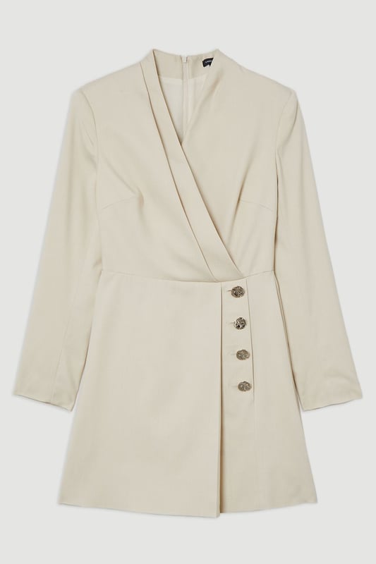 Make a statement with our striking occasion dress, which features a layered design and button detailing. Style it simply with heeled boots or statement heels for a look that will take you from wedding guest days to party season events. Soft Structured Tailored Wrap Blazer Dress Flattering Fitted Silhouette V Neckline Layered Design Unique Wrap Style Button Detailing