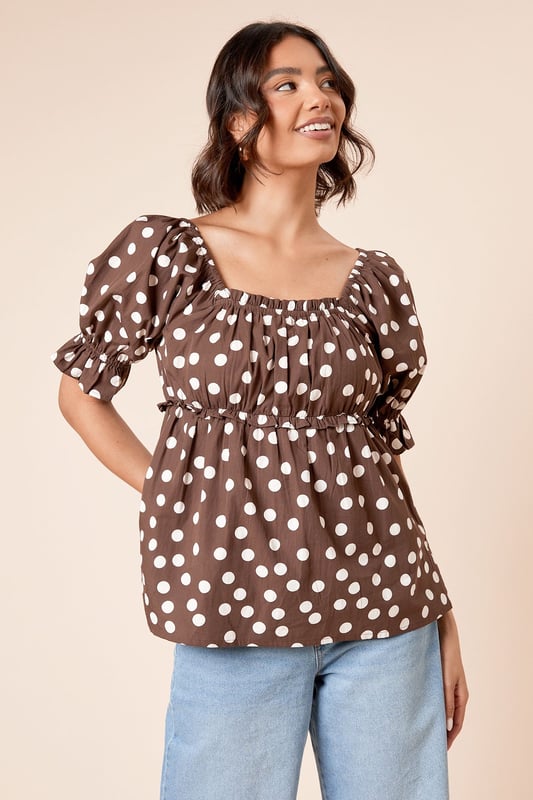 Charming square neckline with delicate gathering detail for a feminine touch
        Playful puff sleeves with elasticated cuffs for a flattering silhouette
        Lightweight cotton poplin fabric ensures breathable comfort throughout the day
        Gathered waist creates a defined shape that complements your figure
        Versatile length perfect for both tucking in or wearing loose over trousers or skirts
    
    This delightful spotted blouse from Dorothy Perkins brings a touch of whimsy to your everyday wardrobe. The square neckline frames your dcolletage beautifully, whilst the gathered detailing adds texture and dimension. Style with your favourite denim jeans and white trainers for casual weekend brunches with the girls, or dress it up with tailored trousers and ballet flats for family gatherings. The cotton fabric ensures you'll stay comfortable all day, whether you're running errands or attending a baby shower. For cooler days, layer under a cardigan or denim jacket without losing any of the blouse's charm. This versatile piece transitions effortlessly from daytime casual to evening meals - simply swap your footwear and add some statement earrings to refresh your look.