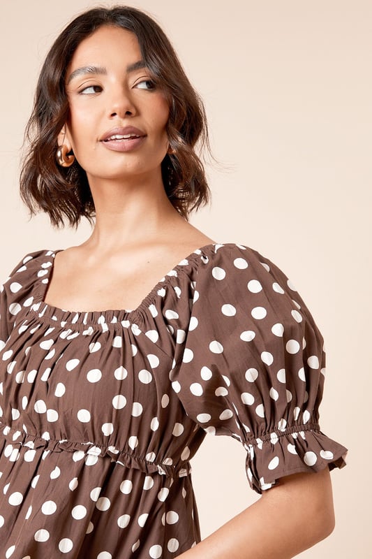 Charming square neckline with delicate gathering detail for a feminine touch
        Playful puff sleeves with elasticated cuffs for a flattering silhouette
        Lightweight cotton poplin fabric ensures breathable comfort throughout the day
        Gathered waist creates a defined shape that complements your figure
        Versatile length perfect for both tucking in or wearing loose over trousers or skirts
    
    This delightful spotted blouse from Dorothy Perkins brings a touch of whimsy to your everyday wardrobe. The square neckline frames your dcolletage beautifully, whilst the gathered detailing adds texture and dimension. Style with your favourite denim jeans and white trainers for casual weekend brunches with the girls, or dress it up with tailored trousers and ballet flats for family gatherings. The cotton fabric ensures you'll stay comfortable all day, whether you're running errands or attending a baby shower. For cooler days, layer under a cardigan or denim jacket without losing any of the blouse's charm. This versatile piece transitions effortlessly from daytime casual to evening meals - simply swap your footwear and add some statement earrings to refresh your look.