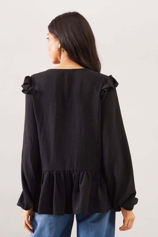 Elegant V-neckline with button-through front detail
        Charming shoulder ruffle trim for a feminine touch
        Relaxed smock silhouette with gathered peplum hem
        Voluminous long sleeves with subtle gathering at cuffs
        Delicate lace trim detailing adds sophisticated texture
    
    This Wallis woven smock top combines comfort with sophisticated style. The flattering V-neckline frames the dcolletage beautifully, whilst the ruffle trim at the shoulders adds a touch of playful femininity. The relaxed fit and peplum hem create a figure-flattering silhouette that drapes gracefully over the body. Style with wide-leg jeans and flat sandals as seen on our model for a chic daytime look perfect for weekend brunches or casual family gatherings. Alternatively, pair with tailored trousers and ballet flats for a smart-casual ensemble ideal for lunch dates or shopping trips. The versatile design transitions effortlessly from day to evening - simply swap your flats for a block heel and add statement earrings for dinner with friends.