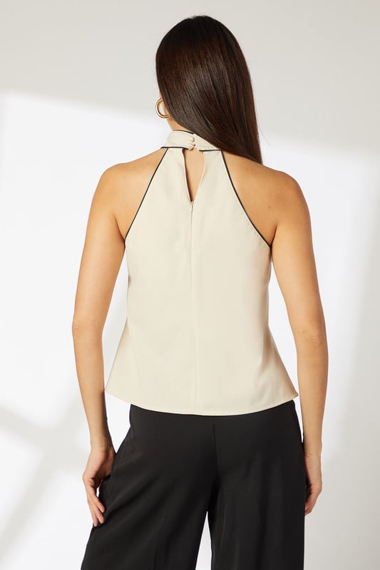 Elegant halterneck design with distinctive contrast piping detail
        Crafted from a breathable linen-cotton blend for all-day comfort
        Sleeveless silhouette with a relaxed fit through the body
        Sophisticated tie detail at the neck for adjustable styling
        Keyhole back fastening adds a subtle touch of refinement
    
    This Principles halterneck top combines effortless style with versatile daywear appeal. The contrast piping detail creates visual interest while the natural fabric blend ensures breathability for warm-weather comfort. Style with wide-leg trousers as shown for a balanced silhouette that works beautifully for lunch dates or gallery visits. For casual weekend outings, pair with your favourite denim and trainers, adding a structured crossbody bag for practical chic. The neutral tone makes this top an excellent canvas for statement jewellery - try bold earrings to draw attention to the elegant neckline. Perfect for family gatherings or informal brunches, this top transitions seamlessly from day to evening with a simple change of accessories. The timeless design ensures this piece will remain a wardrobe favourite for seasons to come.