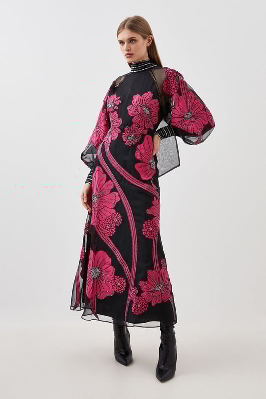 Feel formal in our maxi dress, made with high quality organdie fabric, featuring a fit and flare silhouette that flatters the curves, as well as floral applique accents. Style it with court heels or heeled boots for a look that will take you from party nights and wedding guest days. Applique Organdie Floral Graphic Maxi Dress High Quality Organdie Fabric Comfortable Fit and Flare Silhouette Long Balloon Sleeves Formal, High Neckline Flowing, Sheer Overlay Large, Floral Design Keyhole Back Accent Large Bow Feature Zip Back FasteningBrowse this seasons mother of the bride dresses or shop the full collection of women's wedding outfits now.