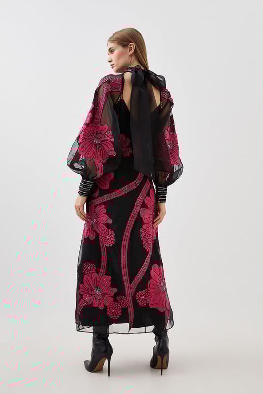 Feel formal in our maxi dress, made with high quality organdie fabric, featuring a fit and flare silhouette that flatters the curves, as well as floral applique accents. Style it with court heels or heeled boots for a look that will take you from party nights and wedding guest days. Applique Organdie Floral Graphic Maxi Dress High Quality Organdie Fabric Comfortable Fit and Flare Silhouette Long Balloon Sleeves Formal, High Neckline Flowing, Sheer Overlay Large, Floral Design Keyhole Back Accent Large Bow Feature Zip Back FasteningBrowse this seasons mother of the bride dresses or shop the full collection of women's wedding outfits now.