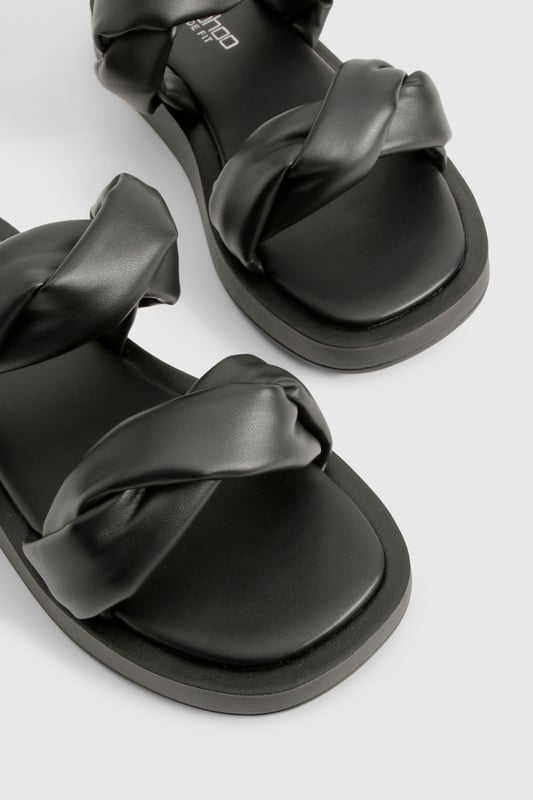 Wide fit design for enhanced comfort and easy wear
        Distinctive twisted strap detail adding contemporary flair
        Flat sole with height between 0-2cm for all-day wearability
        Smooth PU construction offering a sleek, polished finish
        Cushioned footbed providing essential support for extended wear
    
    These statement slides redefine casual footwear with their eye-catching twisted strap detail. The wide fit design ensures maximum comfort whilst the flat sole makes them perfect for those busy days when style can't compromise practicality. Pair with cropped wide-leg trousers and an oversized linen shirt for a sophisticated daytime look, or team with a flowing maxi dress for relaxed weekend brunches. The versatile design transitions effortlessly from poolside lounging to casual city strolls. Their minimalist aesthetic works brilliantly with both neutral tones and vibrant outfits, making them a wardrobe essential for the fashion-forward woman who values both comfort and contemporary style. Ideal for family gatherings, festival outings, or holiday explorations when you need footwear that's as reliable as it is stylish.