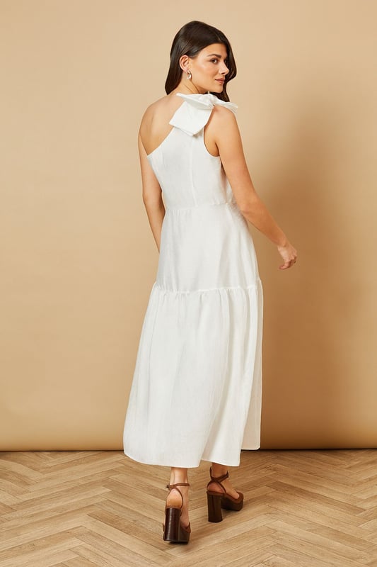 Striking one-shoulder design with an elegant oversized bow detail
        Feminine midi length with a flattering tiered skirt
        Lightweight Tencel fabric that drapes beautifully
        Clean, minimalist silhouette perfect for special occasions
        Versatile design that can be dressed up or down with accessories
    
    This enchanting one-shoulder midi dress showcases Oasis's signature feminine aesthetic with its standout bow shoulder detail. The graceful tiered skirt creates movement and dimension whilst maintaining a sophisticated silhouette. Style with strappy heeled sandals and statement earrings for summer weddings or garden parties. For race day events, pair with a fascinator and clutch bag for a refined ensemble. The versatile design transitions beautifully from daytime celebrations to evening soires-simply switch your accessories to match the occasion. The clean lines and classic shape make this dress a timeless addition to your occasion wardrobe, whilst the midi length offers both elegance and practicality. Perfect for those moments when you want to make a subtle yet memorable impression.