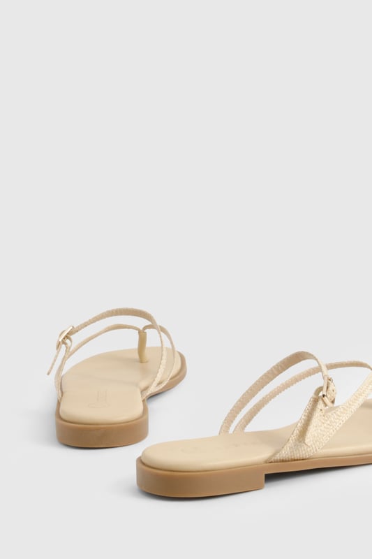 Crafted from natural raffia material for a textured summer look
        Elegant double strap design with delicate toe post detail
        Adjustable buckle fastening for a customised fit
        Flat heel measuring between 0-2cm for all-day comfort
        Versatile neutral tone that complements any summer ensemble
    
    These double-strap sandals offer the perfect blend of style and practicality for your warm-weather wardrobe. The minimalist design features delicate straps that gracefully cross the foot, creating a flattering silhouette that works brilliantly with both casual and semi-formal outfits. Pair with floaty midi dresses and straw accessories for daytime beach strolls, or style with cropped linen trousers and a crisp blouse for family gatherings. The flat sole ensures comfort for extended wear, making these sandals ideal for city sightseeing or garden parties. Their understated elegance allows for effortless transitioning from day to evening - simply add some statement jewellery to transform your look. The adjustable strap ensures these sandals stay securely in place whilst you're on the move, making them a reliable choice for your summer adventures.