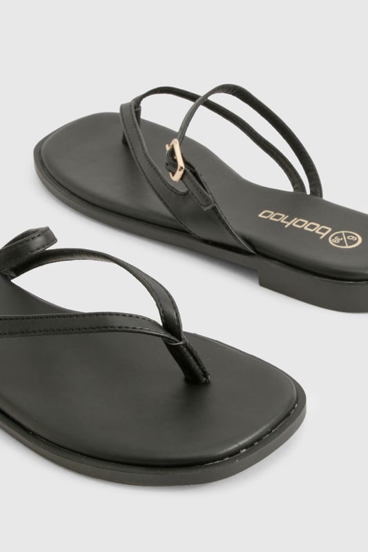 Sleek double strap design with elegant toe post detail
        Flat heel measuring between 0-2cm for all-day comfort
        Delicate gold-tone buckle fastening for adjustable fit
        Smooth PU construction with cushioned footbed
        Versatile slip-on style perfect for effortless summer dressing
    
    These minimalist double strap sandals are the ultimate warm-weather essential for the fashion-forward woman. The understated design features slender straps that delicately cross the foot, creating a flattering silhouette that works brilliantly with everything from floaty summer dresses to casual denim shorts. The practical flat sole ensures comfort for city exploring or beachside strolls, while the subtle gold-tone hardware adds just the right touch of sophistication. Style them with cropped trousers and an oversized linen shirt for daytime casual events, or pair with a flowing maxi dress for family gatherings and garden parties. These versatile sandals transition seamlessly from poolside to pavement, making them an indispensable addition to your holiday packing list and everyday summer wardrobe.