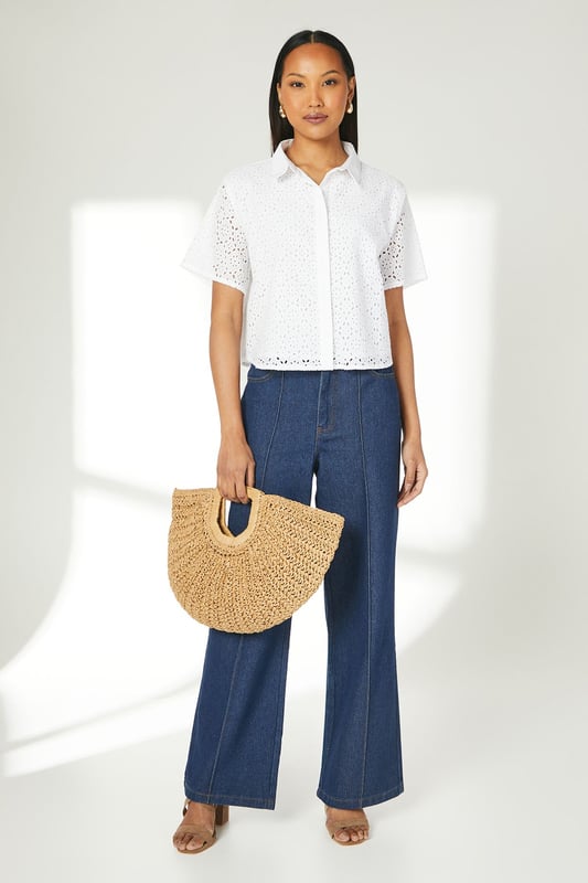 Intricate broderie anglaise pattern throughout
        Collared neckline for a polished look
        Short sleeves with scalloped edges
        Boxy fit for a relaxed silhouette
        Button-down front closure
    
    This charming broderie cotton T-shirt from Principles is a versatile addition to your warm-weather wardrobe. The delicate eyelet detailing adds a touch of femininity, while the boxy fit ensures comfort for all-day wear. Style it with wide-leg trousers and sandals for a chic daytime look perfect for brunches or casual outings. For a more laid-back ensemble, pair it with your favourite denim shorts and trainers for a weekend stroll. The collared neckline allows for easy accessorising - add a dainty necklace to draw attention to the dcolletage. This T-shirt is ideal for various casual events, from family gatherings to shopping trips with friends. Its breathable cotton fabric makes it a go-to choice for balmy summer days, keeping you cool and stylish.