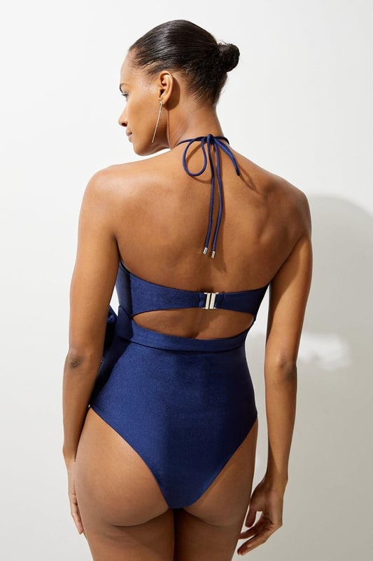 Rosette Cut Out Detail Swimsuit Welcome the sun with a swimming costume that will turn heads, featuring a three dimensional corsage accent on the bust and hip, and a statement cut out design in the front and back. Style this piece with strappy sandals and a beach cover up for a holiday look that can be reworn time and time again. Rosette Cut Out Detail Swimsuit Flattering Halter Neckline Unique, Three Dimensional Flower Accent Statement Cut Out Design Tie and Clasp Fastening in Back