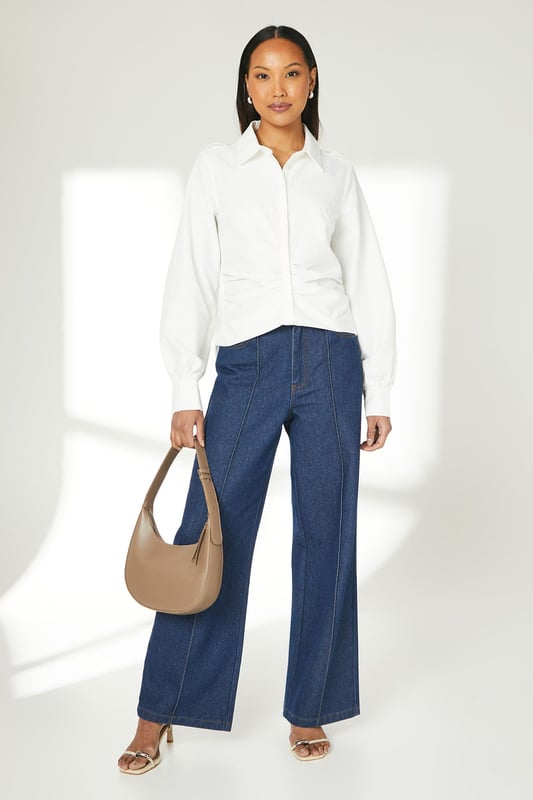 Elegant gathered detailing adds a touch of sophistication
        Long sleeves with subtle volume for a refined silhouette
        Classic collared neckline for a timeless look
        Versatile woven fabric suitable for various occasions
        Button-down front for easy wear and styling options
    
    This Principles gathered detail long sleeve shirt is a versatile addition to your wardrobe, perfect for elevating your everyday style. The subtle gathering adds a feminine touch to the classic shirt design, creating interest without overwhelming the overall look. Style this piece effortlessly for a range of casual events - pair it with wide-leg denim trousers and trainers for a relaxed weekend brunch, or tuck it into a midi skirt with ballet flats for a family gathering. The shirt's adaptable nature allows for easy transition from day to night - simply swap your casual bottoms for tailored trousers and add some statement earrings for an impromptu dinner date. Its neutral palette ensures it will complement a variety of outfits, making it a go-to piece for those moments when you want to look put-together with minimal effort.