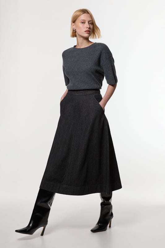 This Karen Millen denim midi skirt is a versatile wardrobe staple that effortlessly bridges the gap between casual and smart-casual attire. The full, flared silhouette creates a graceful movement as you walk, while the high-waisted design accentuates your natural curves. Style it with a fitted knit top and ankle boots for a stylish daytime look, perfect for weekend brunches or casual family gatherings. For a more relaxed vibe, pair it with a simple t-shirt and trainers. The side pockets add a practical touch, ideal for keeping small essentials close at hand. This skirt's adaptable nature makes it suitable for various occasions, from laid-back office days to informal evening outings. Its timeless design ensures it will remain a go-to piece in your wardrobe for seasons to come.  Midi-length denim skirt with a full, flared silhouette High-waisted design for a flattering fit Side pockets for practicality and style Versatile cotton fabric suitable for various seasons Subtle A-line shape creates a feminine profile