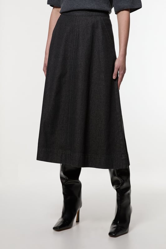 This Karen Millen denim midi skirt is a versatile wardrobe staple that effortlessly bridges the gap between casual and smart-casual attire. The full, flared silhouette creates a graceful movement as you walk, while the high-waisted design accentuates your natural curves. Style it with a fitted knit top and ankle boots for a stylish daytime look, perfect for weekend brunches or casual family gatherings. For a more relaxed vibe, pair it with a simple t-shirt and trainers. The side pockets add a practical touch, ideal for keeping small essentials close at hand. This skirt's adaptable nature makes it suitable for various occasions, from laid-back office days to informal evening outings. Its timeless design ensures it will remain a go-to piece in your wardrobe for seasons to come.  Midi-length denim skirt with a full, flared silhouette High-waisted design for a flattering fit Side pockets for practicality and style Versatile cotton fabric suitable for various seasons Subtle A-line shape creates a feminine profile
