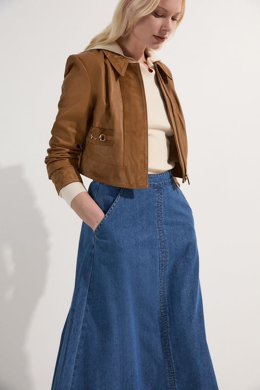 This Karen Millen denim midi skirt is a versatile wardrobe staple that effortlessly bridges the gap between casual and smart-casual attire. The full, flared silhouette creates a graceful movement as you walk, while the high-waisted design accentuates your natural curves. Style it with a fitted knit top and ankle boots for a stylish daytime look, perfect for weekend brunches or casual family gatherings. For a more relaxed vibe, pair it with a simple t-shirt and trainers. The side pockets add a practical touch, ideal for keeping small essentials close at hand. This skirt's adaptable nature makes it suitable for various occasions, from laid-back office days to informal evening outings. Its timeless design ensures it will remain a go-to piece in your wardrobe for seasons to come.  Midi-length denim skirt with a full, flared silhouette High-waisted design for a flattering fit Side pockets for practicality and style Versatile cotton fabric suitable for various seasons Subtle A-line shape creates a feminine profile