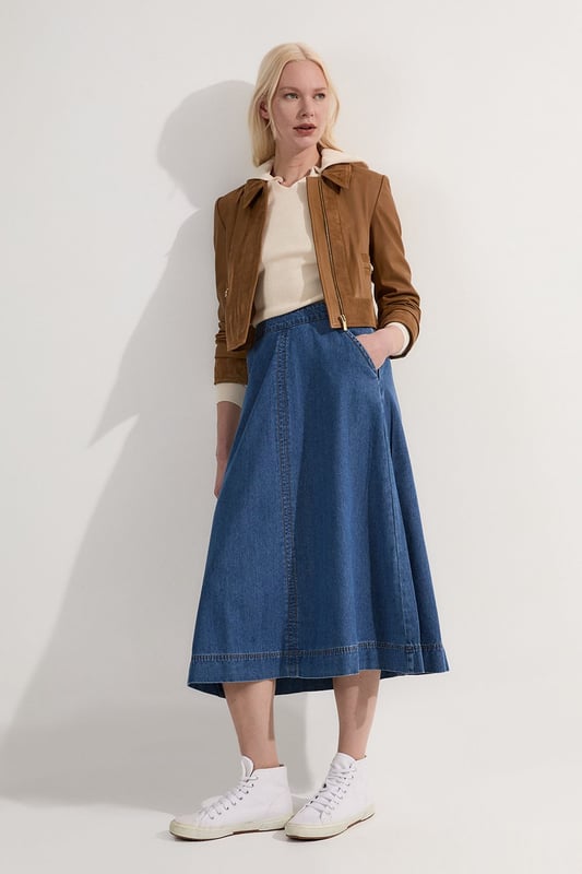 This Karen Millen denim midi skirt is a versatile wardrobe staple that effortlessly bridges the gap between casual and smart-casual attire. The full, flared silhouette creates a graceful movement as you walk, while the high-waisted design accentuates your natural curves. Style it with a fitted knit top and ankle boots for a stylish daytime look, perfect for weekend brunches or casual family gatherings. For a more relaxed vibe, pair it with a simple t-shirt and trainers. The side pockets add a practical touch, ideal for keeping small essentials close at hand. This skirt's adaptable nature makes it suitable for various occasions, from laid-back office days to informal evening outings. Its timeless design ensures it will remain a go-to piece in your wardrobe for seasons to come.  Midi-length denim skirt with a full, flared silhouette High-waisted design for a flattering fit Side pockets for practicality and style Versatile cotton fabric suitable for various seasons Subtle A-line shape creates a feminine profile