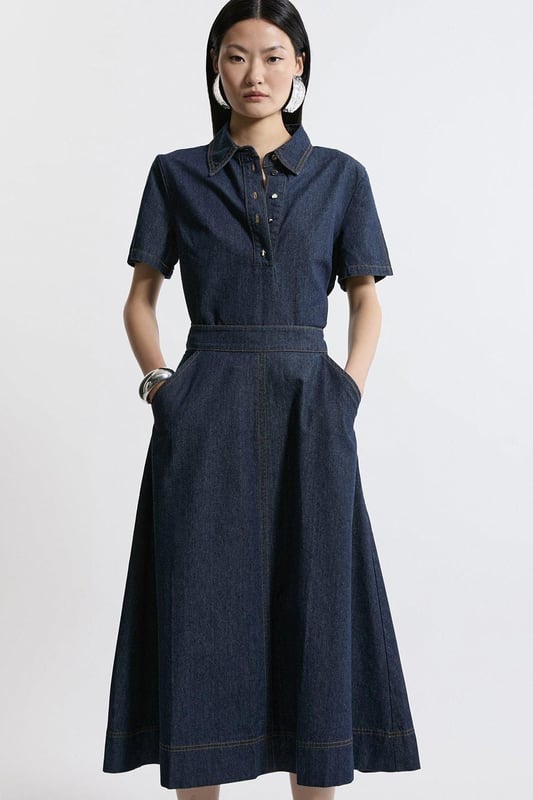 This Karen Millen denim midi skirt is a versatile wardrobe staple that effortlessly bridges the gap between casual and smart-casual attire. The full, flared silhouette creates a graceful movement as you walk, while the high-waisted design accentuates your natural curves. Style it with a fitted knit top and ankle boots for a stylish daytime look, perfect for weekend brunches or casual family gatherings. For a more relaxed vibe, pair it with a simple t-shirt and trainers. The side pockets add a practical touch, ideal for keeping small essentials close at hand. This skirt's adaptable nature makes it suitable for various occasions, from laid-back office days to informal evening outings. Its timeless design ensures it will remain a go-to piece in your wardrobe for seasons to come.  Midi-length denim skirt with a full, flared silhouette High-waisted design for a flattering fit Side pockets for practicality and style Versatile cotton fabric suitable for various seasons Subtle A-line shape creates a feminine profile