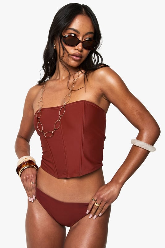 Structured corset-style tankini top with flattering seam detailing
        Strapless bandeau design with supportive boning for shape retention
        Fitted silhouette that accentuates the waistline
        Stretchy knitted fabric for comfortable all-day wear
        Coordinating bottoms complete the two-piece swimwear set
    
    Make a statement poolside with this striking Korsett Tankini-Bikinioberteil from Boohoo. The corset-inspired design brings runway fashion to beachwear, creating a silhouette that's both flattering and fashion-forward. Style with oversized sunglasses and layered jewellery as seen on our model for an Instagram-worthy holiday look. Perfect for lounging by the pool or strolling along the beach, this versatile piece transitions effortlessly from daytime sunbathing to sunset beach club gatherings. For a complete ensemble, pair with a flowing kimono and metallic sandals when moving from poolside to beachfront restaurant. The structured design offers more coverage than a traditional bikini whilst maintaining that head-turning appeal that Boohoo is known for.