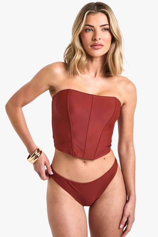 Structured corset-style tankini top with flattering seam detailing
        Strapless bandeau design with supportive boning for shape retention
        Fitted silhouette that accentuates the waistline
        Stretchy knitted fabric for comfortable all-day wear
        Coordinating bottoms complete the two-piece swimwear set
    
    Make a statement poolside with this striking Korsett Tankini-Bikinioberteil from Boohoo. The corset-inspired design brings runway fashion to beachwear, creating a silhouette that's both flattering and fashion-forward. Style with oversized sunglasses and layered jewellery as seen on our model for an Instagram-worthy holiday look. Perfect for lounging by the pool or strolling along the beach, this versatile piece transitions effortlessly from daytime sunbathing to sunset beach club gatherings. For a complete ensemble, pair with a flowing kimono and metallic sandals when moving from poolside to beachfront restaurant. The structured design offers more coverage than a traditional bikini whilst maintaining that head-turning appeal that Boohoo is known for.