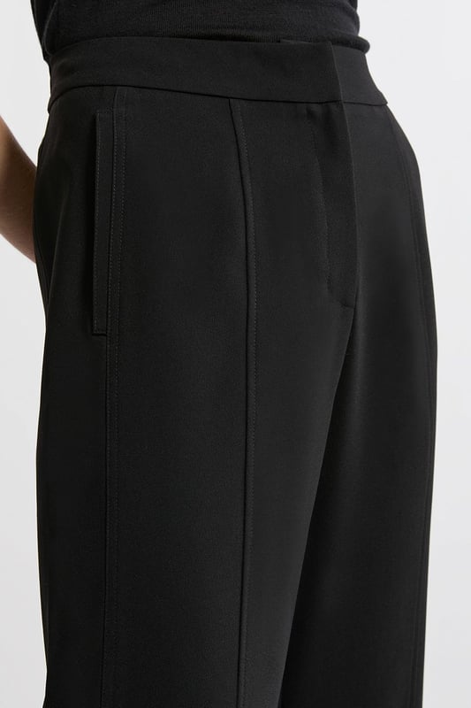 Experience elevated tailoring in a pair of straight leg trousers, featuring a flattering, relaxed fit, seam detailing for a seamless fit, and a comfortable high waistline. The sleek design makes them easy to style with anything, from a crisp button up shirt for a formal look, or with a T-shirt and trainers for a more laid back approach. Tailored Crepe Seam Detail Straight Leg Trousers High Quality Crepe Fabric Comfortable High Waistline Flattering Straight Leg Fit Statement, Pronounced Seam Detailing Pocket Accents Sleek, Minimal Design