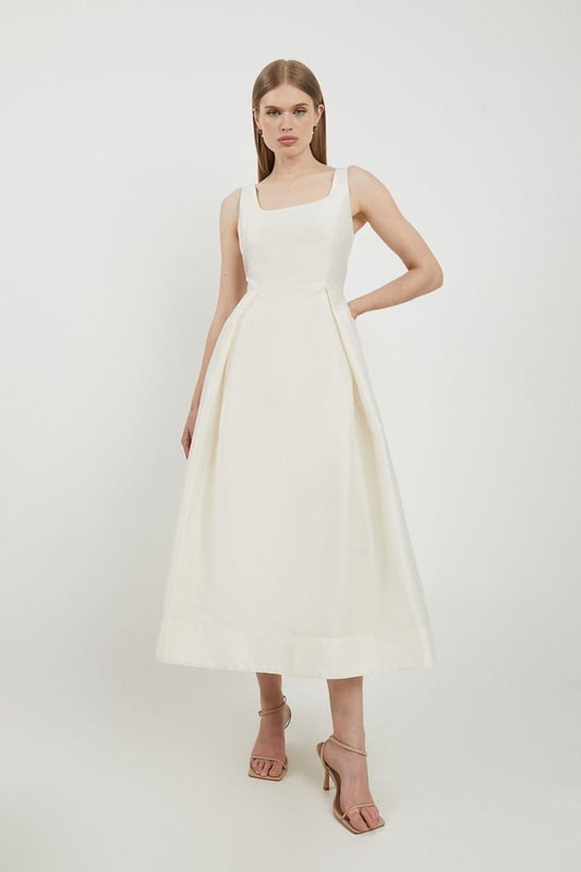 Defined by effortless elegance and timeless sophistication, the new By Lydia: Summer '24 collection captures Lydia Millen's signature style. Feel elegant in our midi dress, with a universally flattering silhouette, a long skirt that creates flowing movement, and a square neckline, perfect for introducing some old-school glamour to your wardrobe. Style this dress with strappy heels for an outfit that will turn heads from wedding guest days to upcoming occasions and events. Lydia Millen Taffeta Full Skirt Tailored Midi Dress High Quality Taffeta Fabric Formal, Flowing Skirt Flattering Fit and Flare Silhouette Square Neckline Comfortable, Wide Shoulder Straps Midi Length Zip Fastening in BackBrowse this seasons work dresses or discover the full range of workwear now.