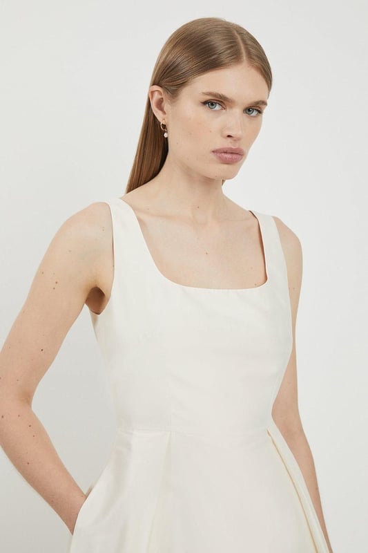 Defined by effortless elegance and timeless sophistication, the new By Lydia: Summer '24 collection captures Lydia Millen's signature style. Feel elegant in our midi dress, with a universally flattering silhouette, a long skirt that creates flowing movement, and a square neckline, perfect for introducing some old-school glamour to your wardrobe. Style this dress with strappy heels for an outfit that will turn heads from wedding guest days to upcoming occasions and events. Lydia Millen Taffeta Full Skirt Tailored Midi Dress High Quality Taffeta Fabric Formal, Flowing Skirt Flattering Fit and Flare Silhouette Square Neckline Comfortable, Wide Shoulder Straps Midi Length Zip Fastening in BackBrowse this seasons work dresses or discover the full range of workwear now.