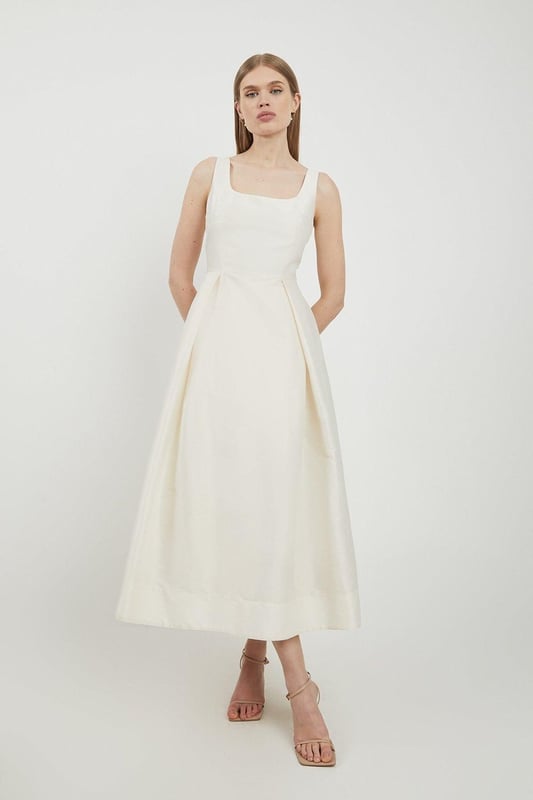 Defined by effortless elegance and timeless sophistication, the new By Lydia: Summer '24 collection captures Lydia Millen's signature style. Feel elegant in our midi dress, with a universally flattering silhouette, a long skirt that creates flowing movement, and a square neckline, perfect for introducing some old-school glamour to your wardrobe. Style this dress with strappy heels for an outfit that will turn heads from wedding guest days to upcoming occasions and events. Lydia Millen Taffeta Full Skirt Tailored Midi Dress High Quality Taffeta Fabric Formal, Flowing Skirt Flattering Fit and Flare Silhouette Square Neckline Comfortable, Wide Shoulder Straps Midi Length Zip Fastening in BackBrowse this seasons work dresses or discover the full range of workwear now.