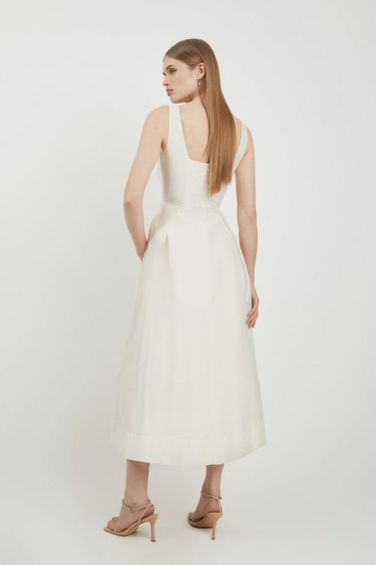 Defined by effortless elegance and timeless sophistication, the new By Lydia: Summer '24 collection captures Lydia Millen's signature style. Feel elegant in our midi dress, with a universally flattering silhouette, a long skirt that creates flowing movement, and a square neckline, perfect for introducing some old-school glamour to your wardrobe. Style this dress with strappy heels for an outfit that will turn heads from wedding guest days to upcoming occasions and events. Lydia Millen Taffeta Full Skirt Tailored Midi Dress High Quality Taffeta Fabric Formal, Flowing Skirt Flattering Fit and Flare Silhouette Square Neckline Comfortable, Wide Shoulder Straps Midi Length Zip Fastening in BackBrowse this seasons work dresses or discover the full range of workwear now.