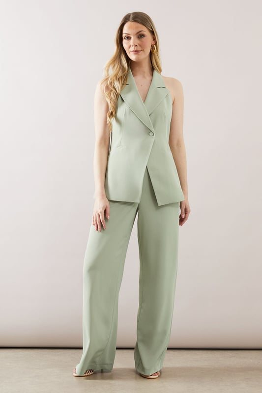 Collared Longline Waistcoat Sleek longline waistcoat with a sophisticated collar
Halterneck design for a modern, chic look
Wide-leg trousers with a flattering high waist
Side pockets for practicality and style
Back split detail on trousers for ease of movement
This collared longline waistcoat ensemble from Wallis is the epitome of contemporary sophistication. Perfect for the woman who appreciates glamour with a comfortable edge, this set is versatile enough for various occasions. The sleek waistcoat, featuring a halterneck design, pairs beautifully with the wide-leg trousers, creating a flowing silhouette that's both flattering and on-trend. For a casual yet polished look, style with minimalist jewellery and strappy sandals. When attending family gatherings or informal events, layer with a lightweight blouse underneath for added dimension. The ensemble's clean lines and elegant simplicity make it an ideal choice for those seeking a refined appearance without sacrificing comfort. Customise the look with a statement belt to define the waist or leave it open for a more relaxed feel. This Wallis piece promises to be a versatile addition to your wardrobe, ready to take you from day to night with effortless grace.