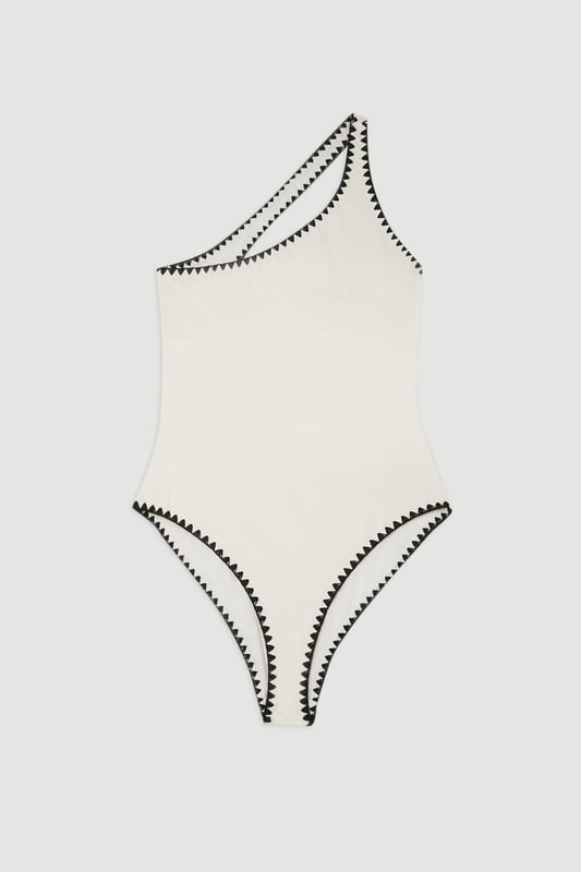 Welcome the sun with a swimsuit that will turn heads, featuring a statement one shoulder design, contrasting stitch details, and a low back. Style this piece with strappy sandals and a beach cover up for a holiday look that can be reworn time and time again. Stitch Detail One Shoulder Cut Out Swimsuit Contrasting Stitch Accents Flattering One Shoulder Design Statement Open Back