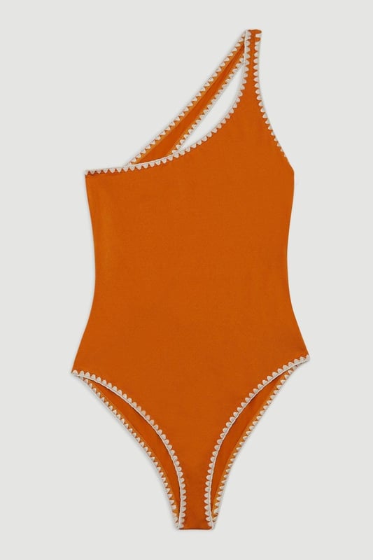 Welcome the sun with a swimsuit that will turn heads, featuring a statement one shoulder design, contrasting stitch details, and a low back. Style this piece with strappy sandals and a beach cover up for a holiday look that can be reworn time and time again. Stitch Detail One Shoulder Cut Out Swimsuit Contrasting Stitch Accents Flattering One Shoulder Design Statement Open Back
