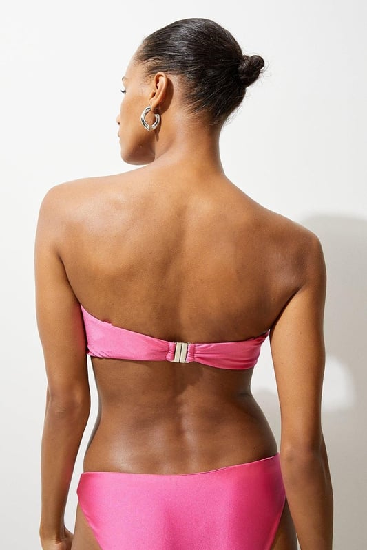 Welcome the sun with a bikini that will turn heads, the top of which features a three dimensional corsage accent at the cleavage, and a comfortable bandeau style, with optional, wide shoulder straps. Style this piece with the matching bikini bottoms, strappy sandals, and a beach cover up for a holiday look that can be reworn time and time again. Rosette Detail Bandeau Bikini Top Comfortable Bandeau Style Unique, Three Dimensional Flower Accent at Cleavage Optional, Wide Shoulder Straps Clasp Fastening in Back Matching Bikini Bottoms Sold Separately