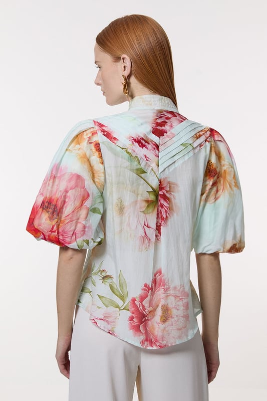 Silk Cotton Short Sleeve Pintuck Woven Blouse This Karen Millen woven blouse radiates refinement and charm, perfect for those seeking a statement piece for formal occasions. The pintuck detailing along the front adds texture and visual interest, while the high neckline lends an air of sophistication. The voluminous short sleeves create a dramatic silhouette, balancing the loose fit of the body. Style this blouse with tailored trousers and pointed-toe heels for a polished look at weddings or corporate events. For a more relaxed yet stylish ensemble, pair it with a sleek pencil skirt and strappy sandals. The versatility of this piece allows for effortless transition from day to evening wear, making it a valuable addition to any wardrobe. Accessorise with delicate gold jewellery to complement the blouse's elegant design and create a cohesive, stylish appearance. Exquisite silk-cotton blend for luxurious comfort Striking pintuck detailing along the front placket Voluminous short sleeves for a dramatic silhouette High neckline adds sophistication and elegance Button-front closure for easy wear and versatility