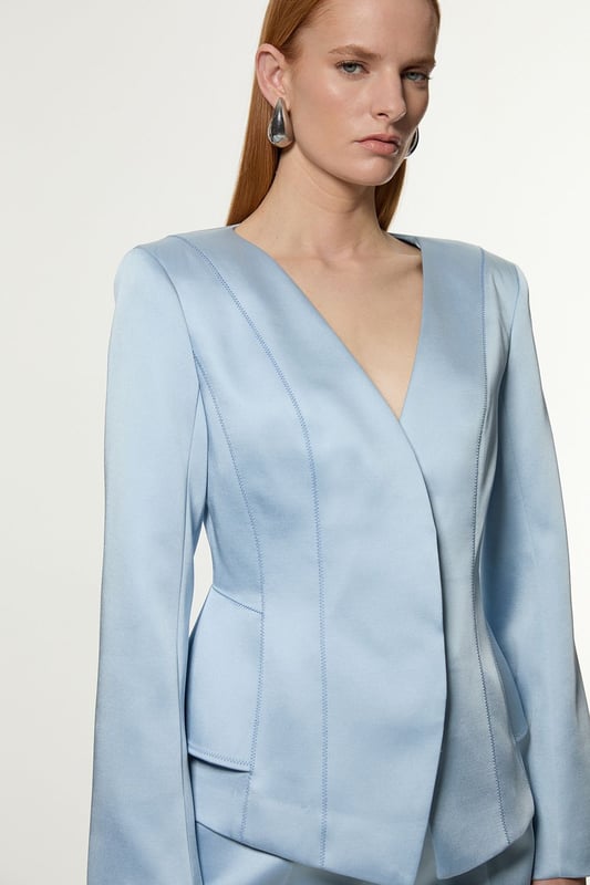 This Karen Millen blazer is a versatile piece that seamlessly transitions from day to night. The structured viscose satin fabric lends a sophisticated sheen, whilst the tailored peplum design creates a figure-flattering shape. Perfect for formal occasions, pair it with matching trousers for a chic suit ensemble or dress it down with dark-wash jeans for a smart-casual look. The stitch detailing adds a touch of refinement, making it an ideal choice for weddings, races, or important business meetings. Layer it over a silk camisole or crisp white shirt for added versatility. This blazer is a wardrobe essential that will serve you well for years to come, offering endless styling possibilities for the fashion-forward British woman.   Structured viscose satin fabric for a luxurious look and feel Tailored peplum design for a flattering silhouette Stitch detail adds subtle texture and visual interest V-neckline creates an elegant and feminine look Slim fit accentuates curves while maintaining a polished appearance