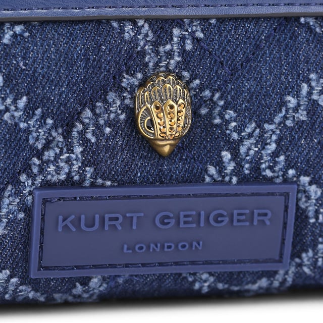 This Extra Small Denim Cross bag features a blue denim exterior with frayed diamond weave design. There is an antiqued brass eagle head on the front above a rubber branded patch. 19cm (H), 18cm (L), 5cm (D). Strap length: 120cm. Removable cross body woven strap. Can fit phones up to 6inches.