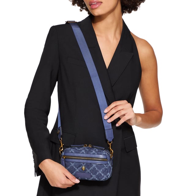 This Extra Small Denim Cross bag features a blue denim exterior with frayed diamond weave design. There is an antiqued brass eagle head on the front above a rubber branded patch. 19cm (H), 18cm (L), 5cm (D). Strap length: 120cm. Removable cross body woven strap. Can fit phones up to 6inches.