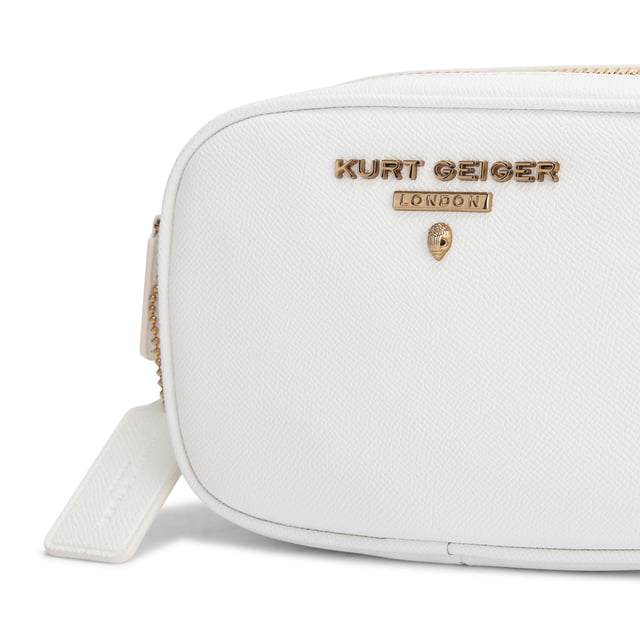 This Kurt Geiger Small Chiswick Camera Bag features a white pebble grain leather exterior. There is an antiqued brass logo and micro eagle head on the front of the bag and open pocket on the back. Dimensions: 13cm (H), 19cm (L), 6cm (D). Strap length: 236cm.