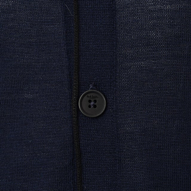 Paul Smith Mens Cardigan In Navy in Navy The Cardigan in Navy is crafted from 100% merino wool, offering a luxurious feel with warmth and softness. The classic knitted design ensures versatility, making it a great choice for both casual and formal occasions. The navy color is timeless and complements various outfits. Here's the size guide: