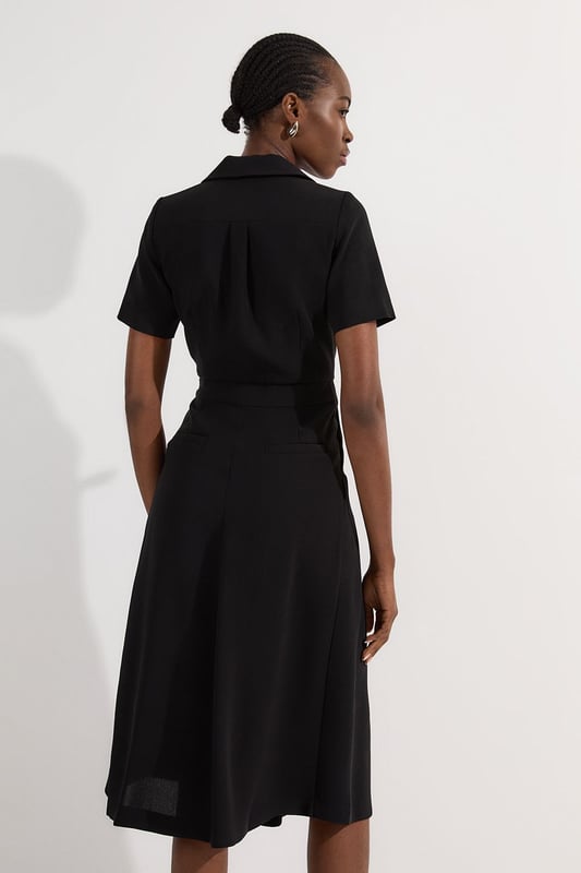This Karen Millen soft tailored midi dress strikes the perfect balance between professional polish and feminine charm. The classic collared design and pleated detailing create a sophisticated silhouette that commands attention in any boardroom or office setting. Style with pointed court shoes and a structured tote for daytime meetings, or transition to evening networking events with statement earrings and a sleek clutch. The belted waist offers customisable definition, whilst the midi length ensures appropriate coverage for formal workplace settings. This versatile piece works beautifully layered under a tailored blazer during cooler months or worn alone when temperatures rise. A timeless addition to your workwear rotation that delivers effortless elegance with practical comfort.  Elegant collared neckline with a sophisticated V-opening for a refined workwear silhouette Short sleeves offering comfortable coverage whilst maintaining a professional appearance Stylish D-ring belt detail that cinches the waist for a flattering, feminine shape Graceful pleated skirt with a flowing midi length that creates elegant movement Practical side pockets discreetly integrated into the design for functionality