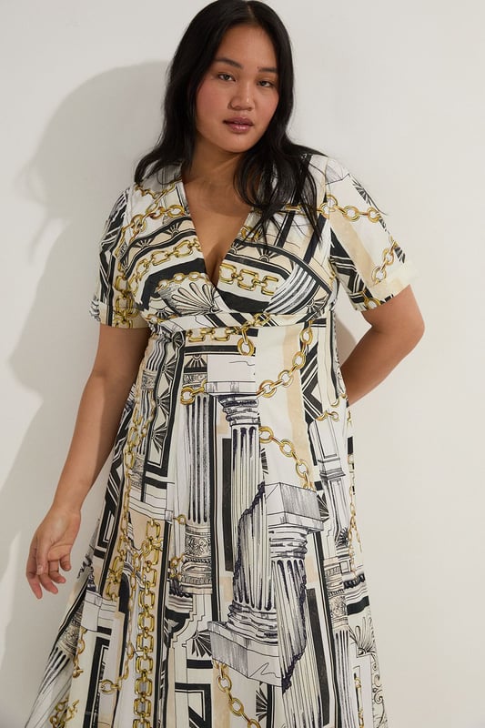 Striking Roma print featuring architectural motifs and chain details Flattering V-neckline and short sleeves Full skirt design for a dramatic silhouette Midi length perfect for various occasions Crafted from soft cotton sateen for comfort and style  Make a statement in this eye-catching Karen Millen plus size midi dress. The Roma print, adorned with architectural elements and chain motifs, creates a captivating visual impact. The V-neckline and short sleeves offer a flattering frame, while the full skirt adds a touch of drama to your ensemble. Perfect for daytime events, this dress can be styled with flat sandals and a tote bag for a casual lunch date or family gathering. Layer with a denim jacket for a more relaxed look, or add a belt to accentuate your waist. The versatile midi length allows for easy transition from day to evening, making it a go-to piece for various occasions. Embrace the artistic print and let this dress become the focal point of your outfit, pairing it with minimal accessories to let the design truly shine.